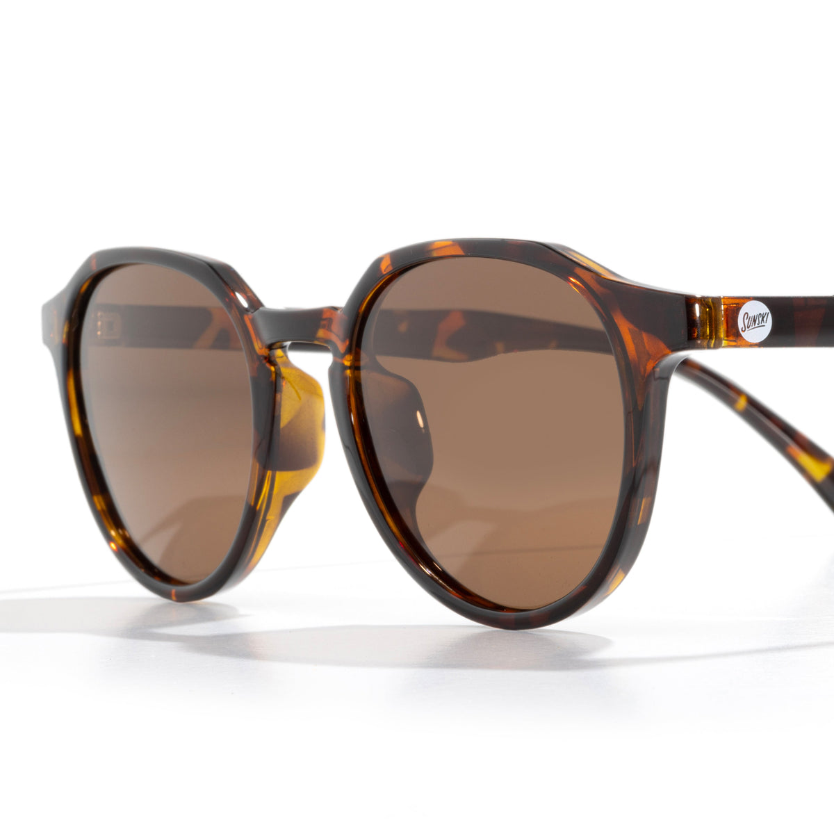 Sunglasses with tortoiseshell frame and brown lenses on a white background