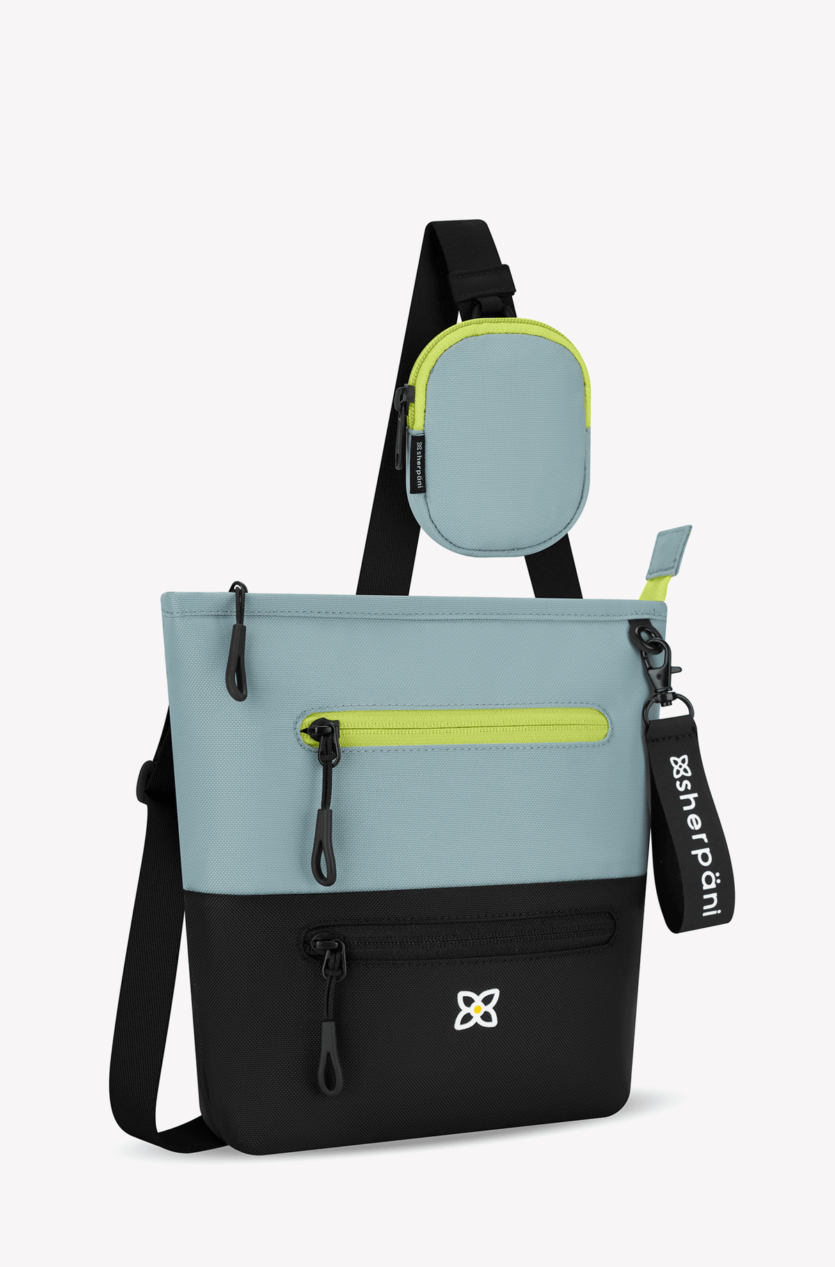 Angled front view of Sherpani&#39;s crossbody, the Sadie in St. Lucia. The top half of the bag is aqua blue accented by a light green trim and the bottom half of the bag is black. It features two exterior zipper pockets on the front panel with easy-pull zippers. A Sherpani branded keychain is attached to a fabric loop in the upper right corner. It has an adjustable crossbody strap. #color_st-lucia