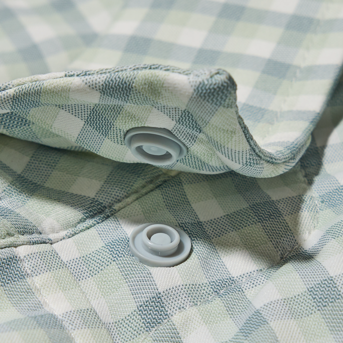 close up of collar button on green plaid long sleeve