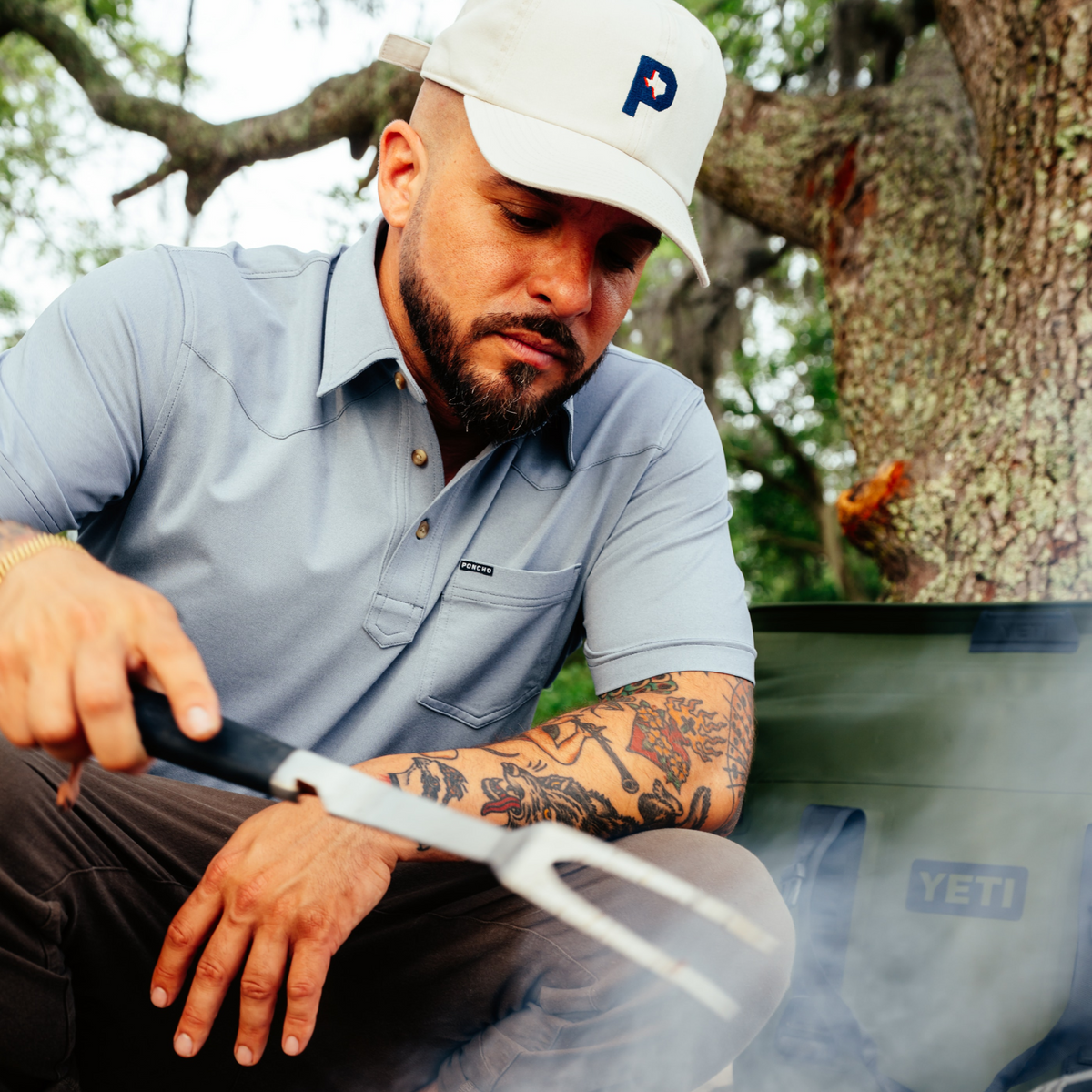 man cooking wearing the 2 stroke performance polo