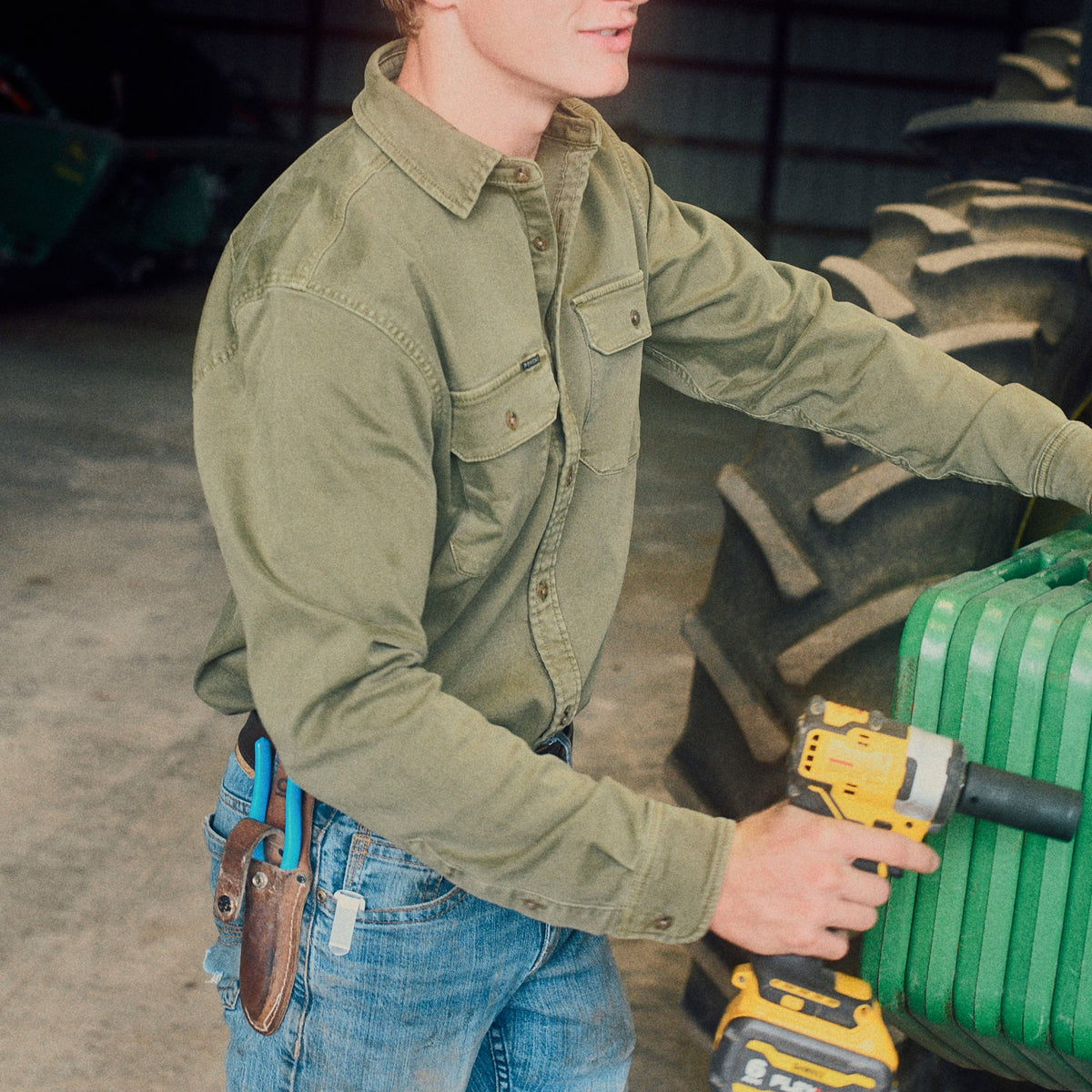The Buck Snort olive work shirt worn while repairing a tractor with a power drill