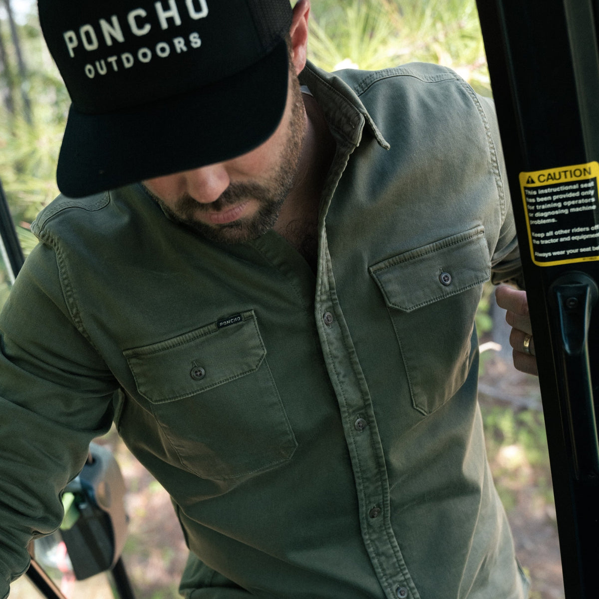 The Buck Snort green outdoor shirt worn by a bearded man in the woods
