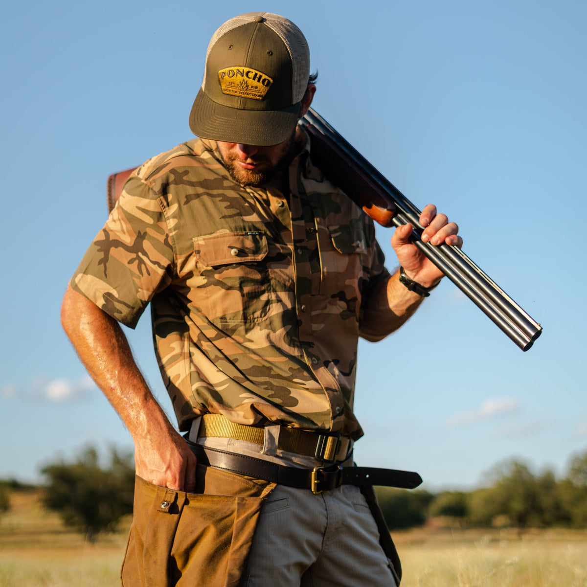 Man wearing The Cordoba camouflage shirt holding a shotgun outdoors