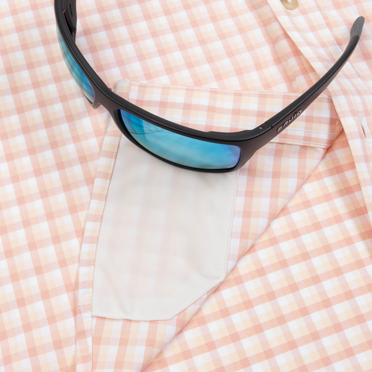 sunglasses with lens cleaner on shirt