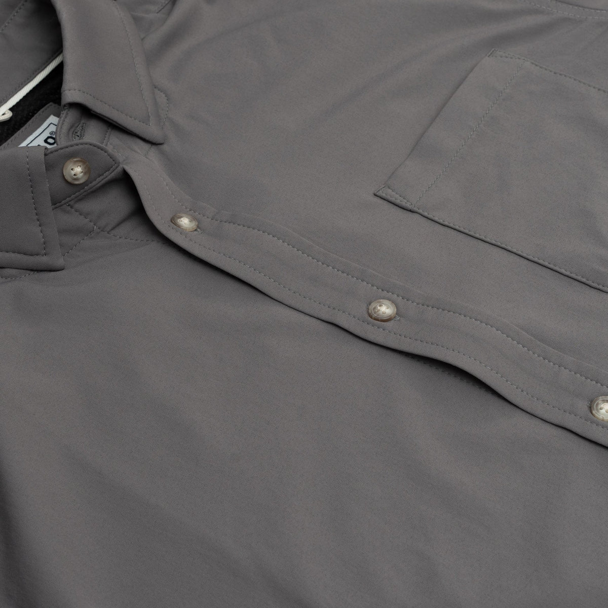 close up product photo of buttons and pockets on grey button down shirt