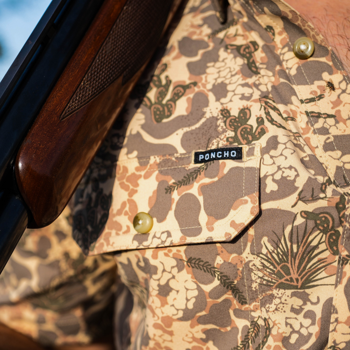 Close-up of a patterned shirt pocket featuring a Poncho tag on The Albany shirt, outdoors style.