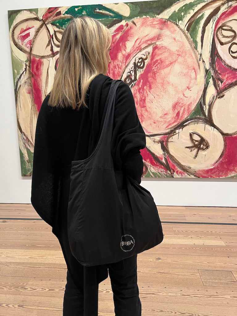 woman in gallery with bag over shoulder