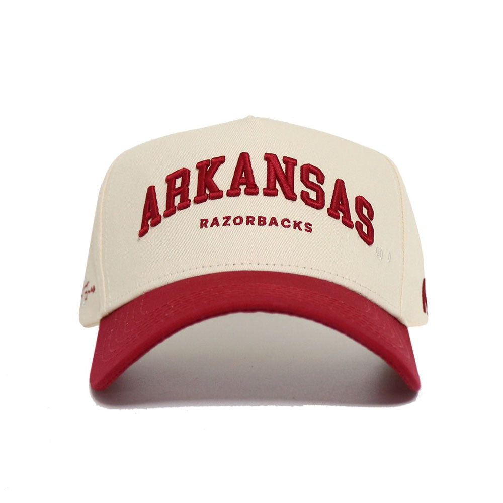 The No Rivals Arkansas Razorback Hat features cream and red colors, bold ARKANSAS and RAZORBACKS lettering, a snapback closure, and an eye-catching red bill—an officially licensed cap perfect for your gameday look.