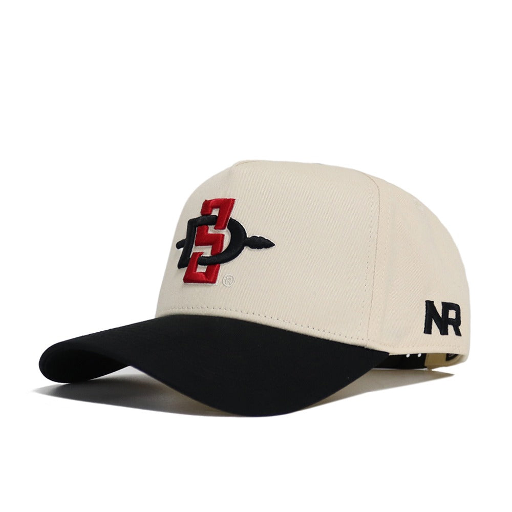 The Classic San Diego State Hat (B2B) by No Rivals is a beige cotton baseball cap with a black curved brim, a red and black front embroidered logo, and "NR" stitched in black on the side.