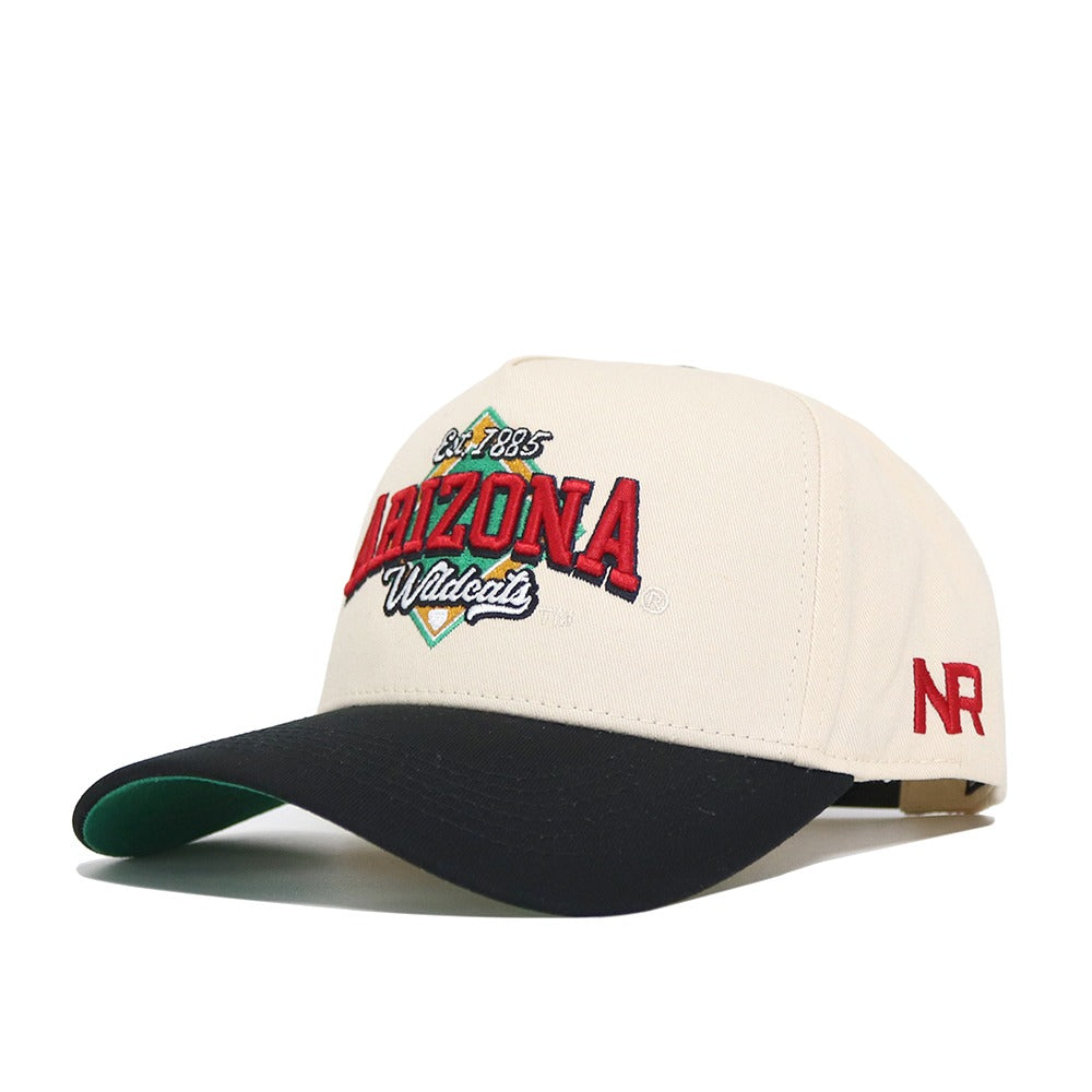 The No Rivals Arizona Ballpark Hat features a cream crown, black brim, and high-quality cotton. Embroidered front text reads "Est. 1885 ARIZONA Wildcats" in red, green, and black with "NR" in red on the side. Structured fit for lasting style.