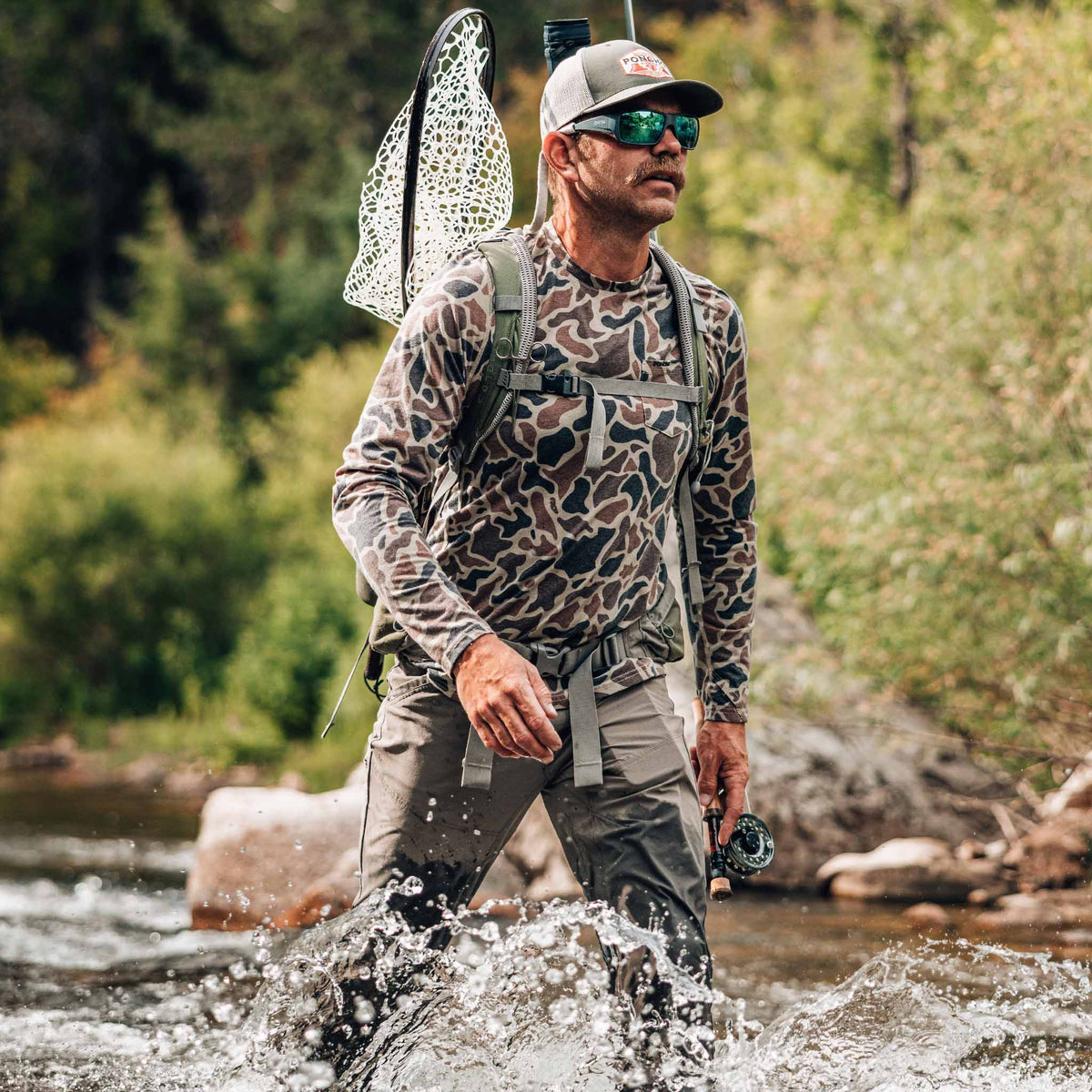man walking in water wearing camo crew