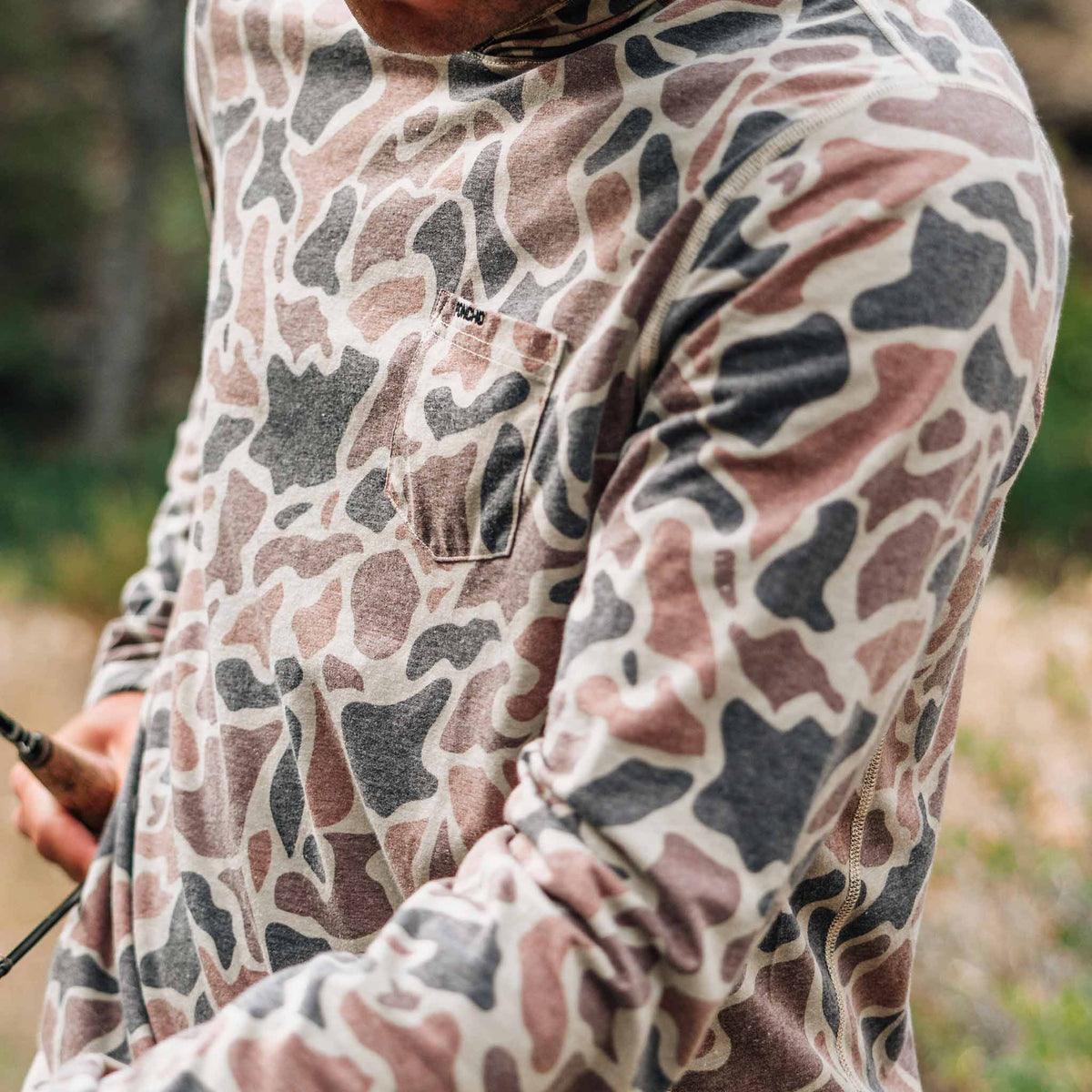 man with fishing rod wearing camo hoodie