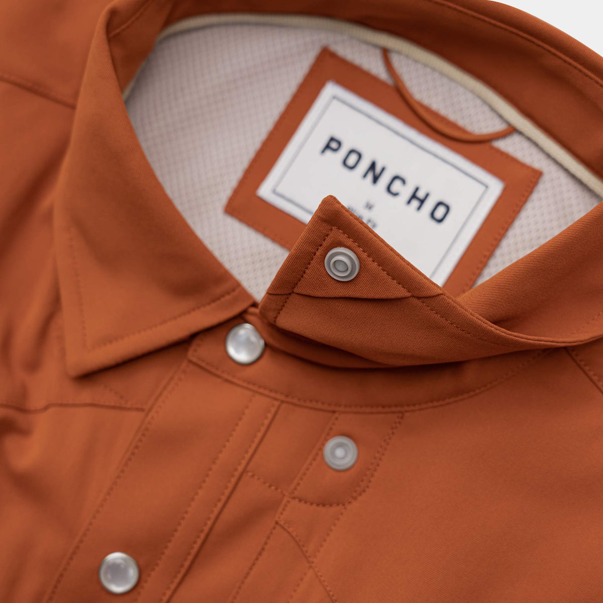 Close up of burnt orange shirt collar and collar snaps