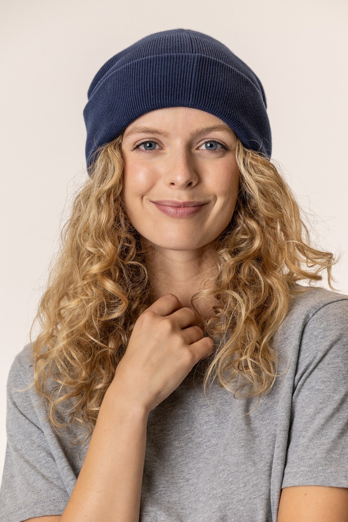 Woman wearing a navy blue beanie made of organic cotton