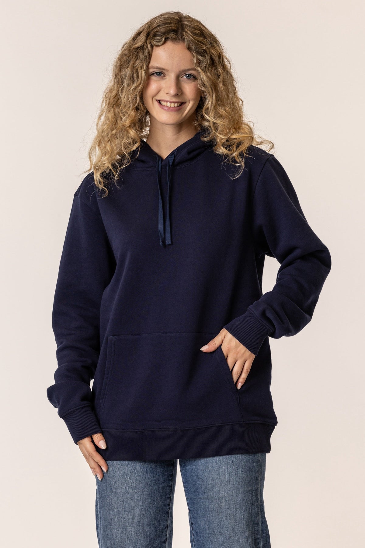 Woman wearing a navy blue pullover hoodie#color_navy-blue