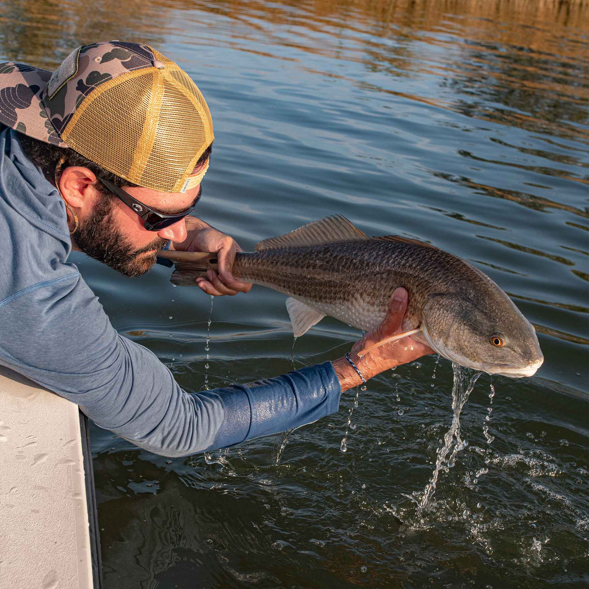 man with fish wearing slate blue hoodie