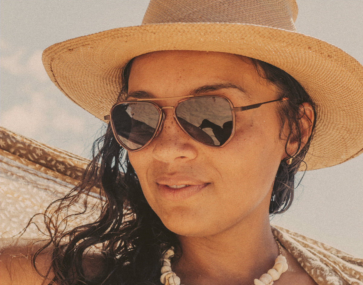 STORY woman in a straw hat wearing sunski astra sunglasses