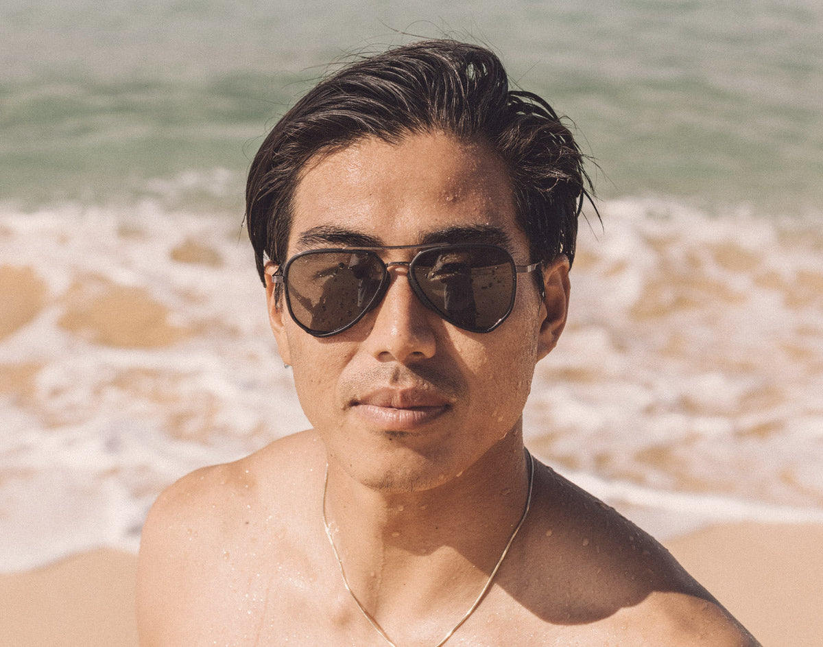 STORY guy at the beach wearing sunski astra sunglasses