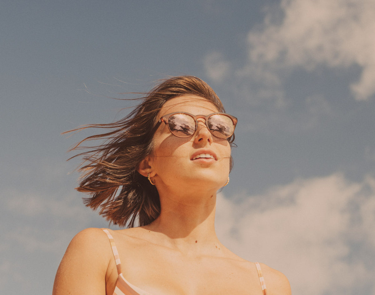 STORY girl in the wind wearing sunski avila sunglasses