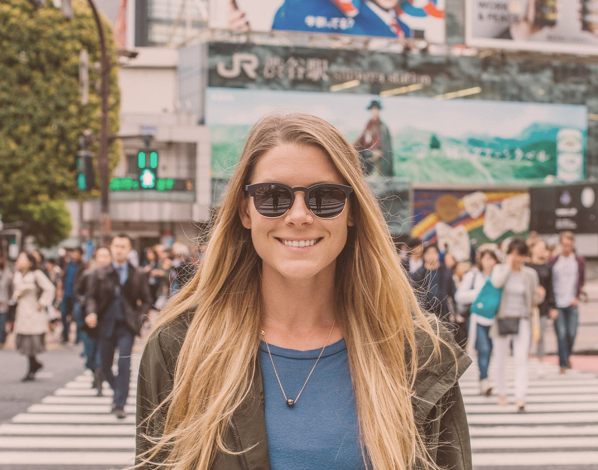 STORY girl in a city wearing sunski avila sunglasses