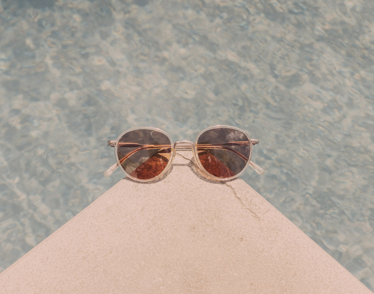 STORY sunski baia sunglasses on a corner by a pool