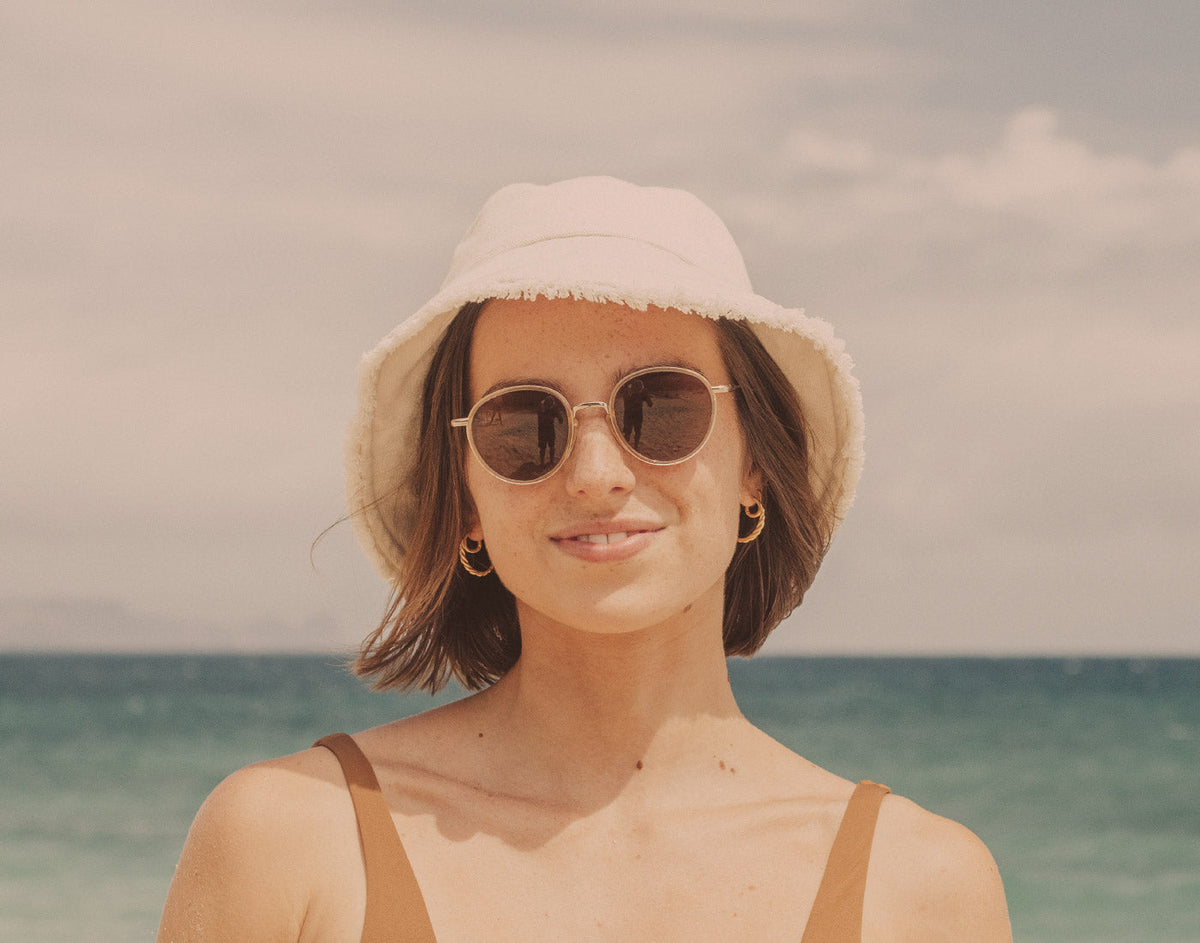 STORY girl in bucket hat wearing sunski baia sunglasses
