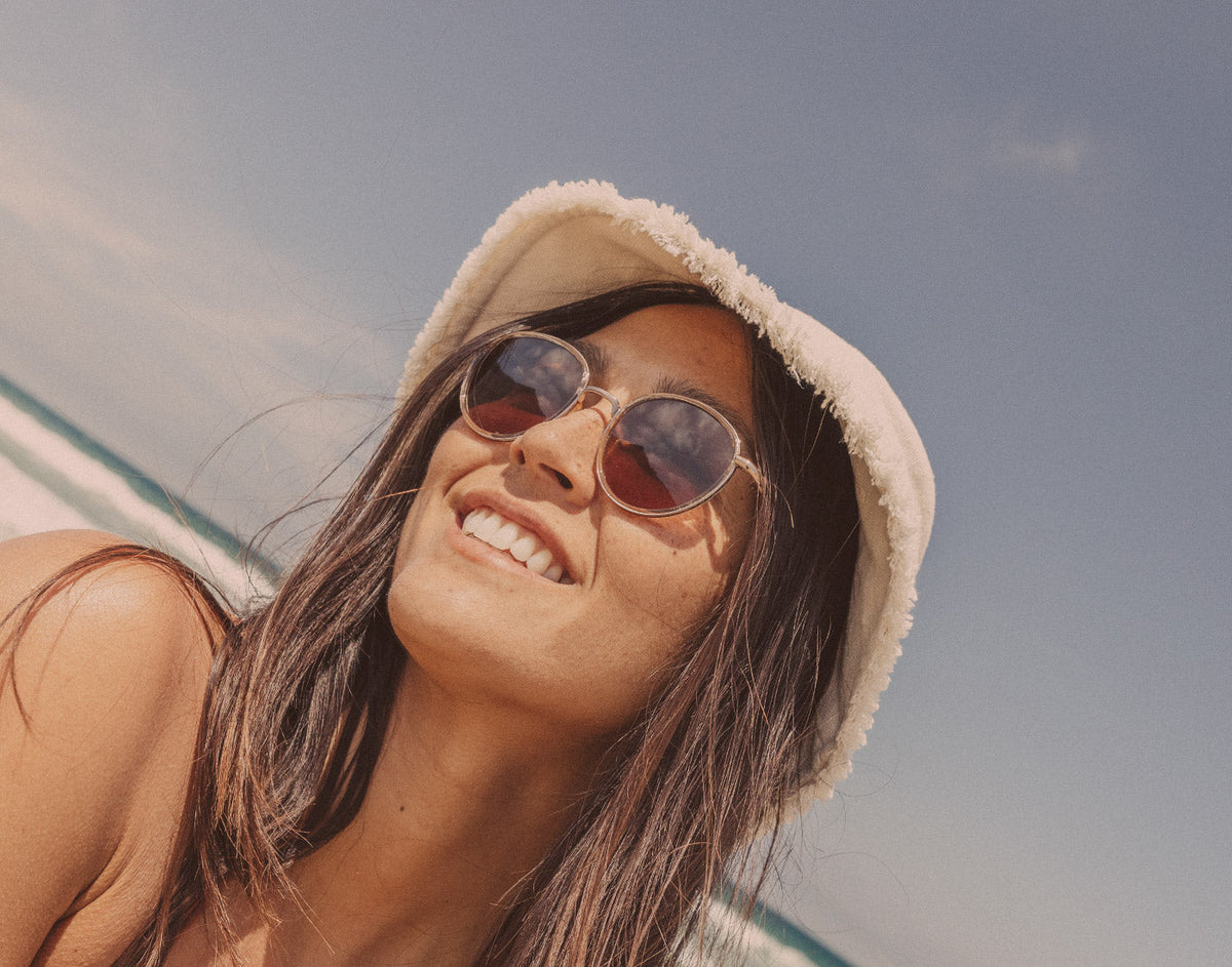 STORY girl looking diagonally in bucket hat wearing sunski baia sunglasses