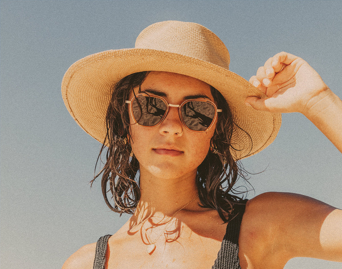 STORY woman in a straw hat wearing sunski bernina sunglasses