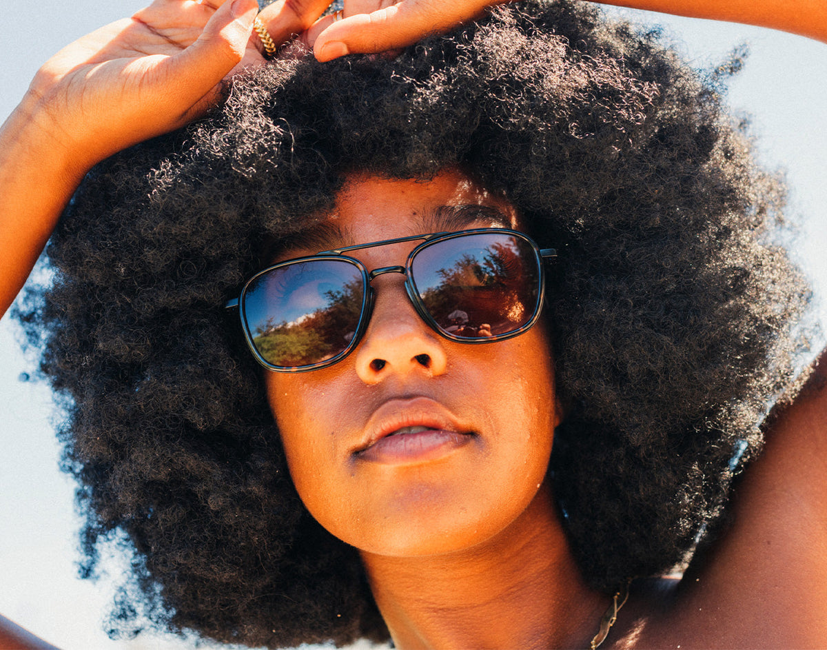 STORY girl with hands on head wearing sunski estero sunglasses