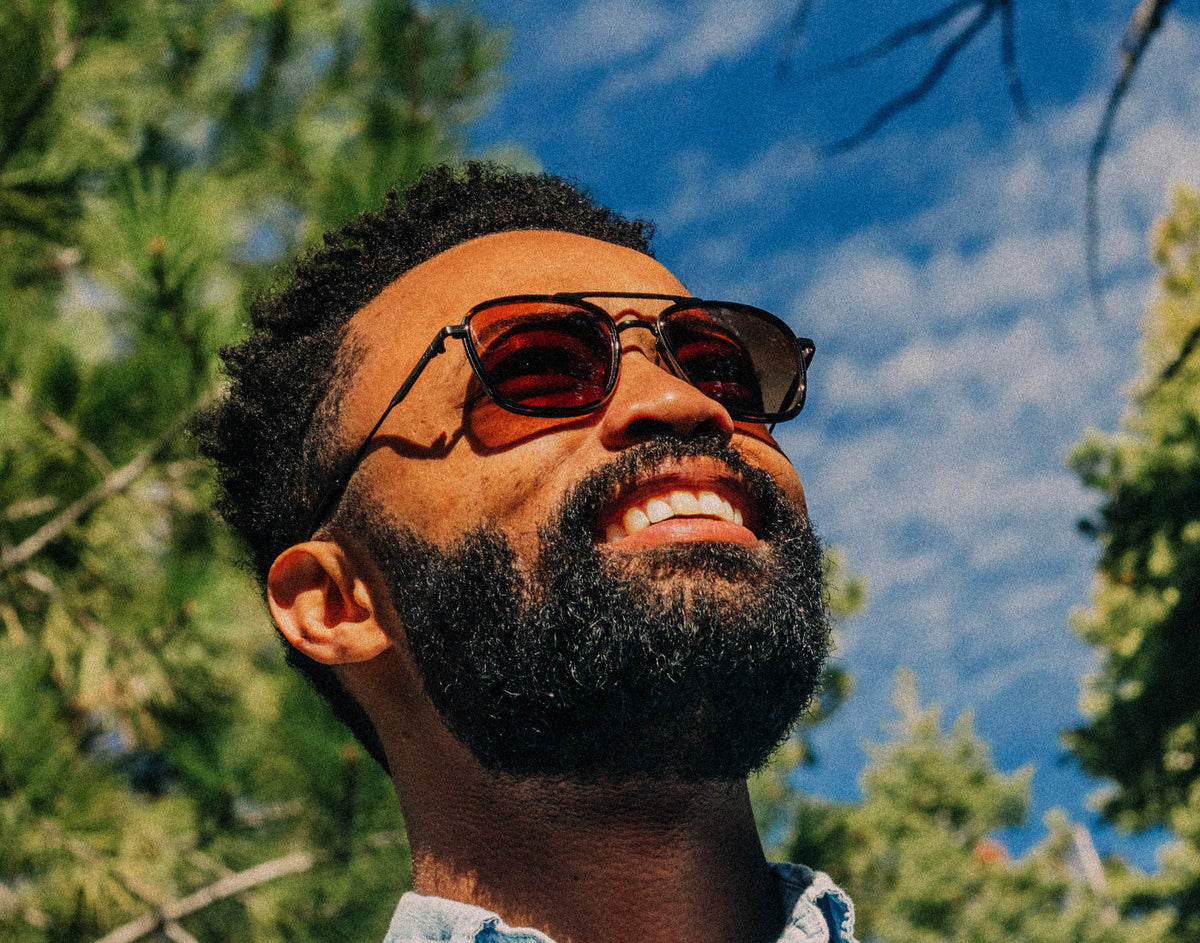 STORY man looking up at the sky wearing sunski estero sunglasses