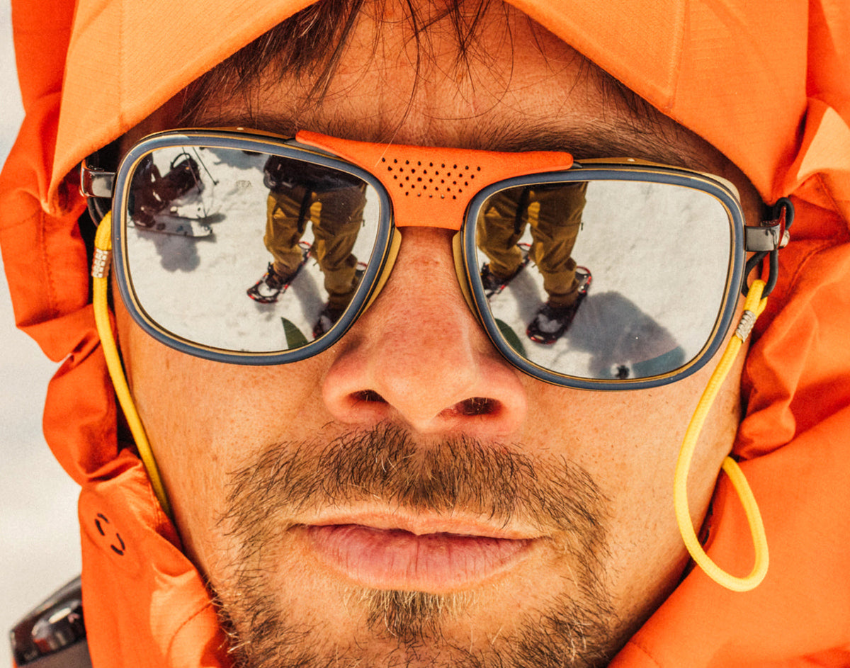 STORY close up of man with hood on wearing sunski ferrata sunglasses