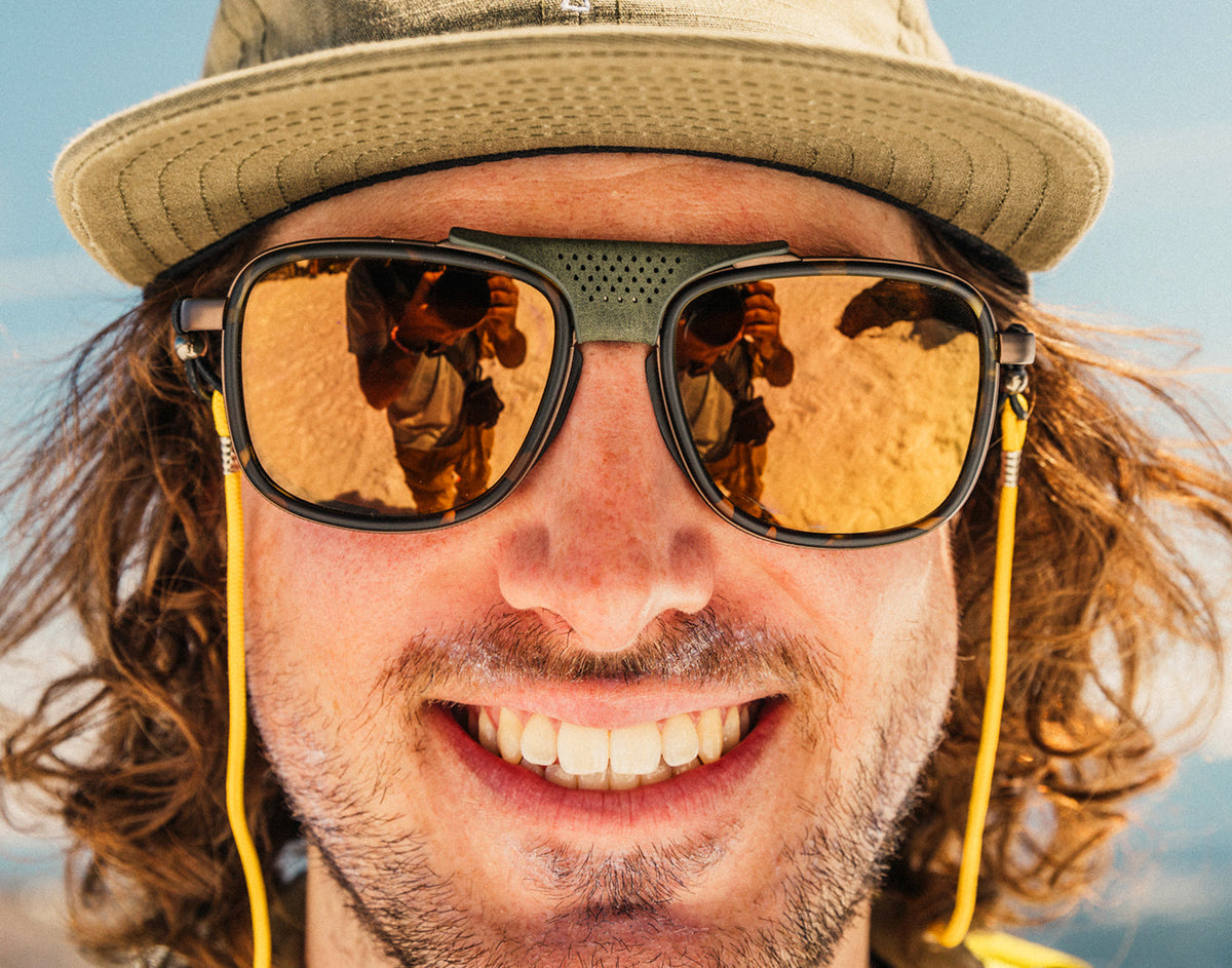 STORY close up of man wearing a hat in sunski ferrata sunglasses