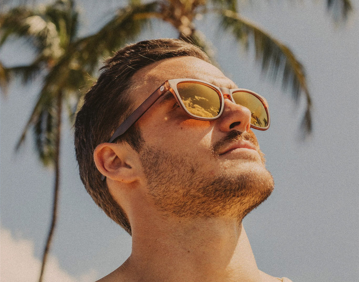 STORY man looking up to sun wearing sunski headland sunglasses