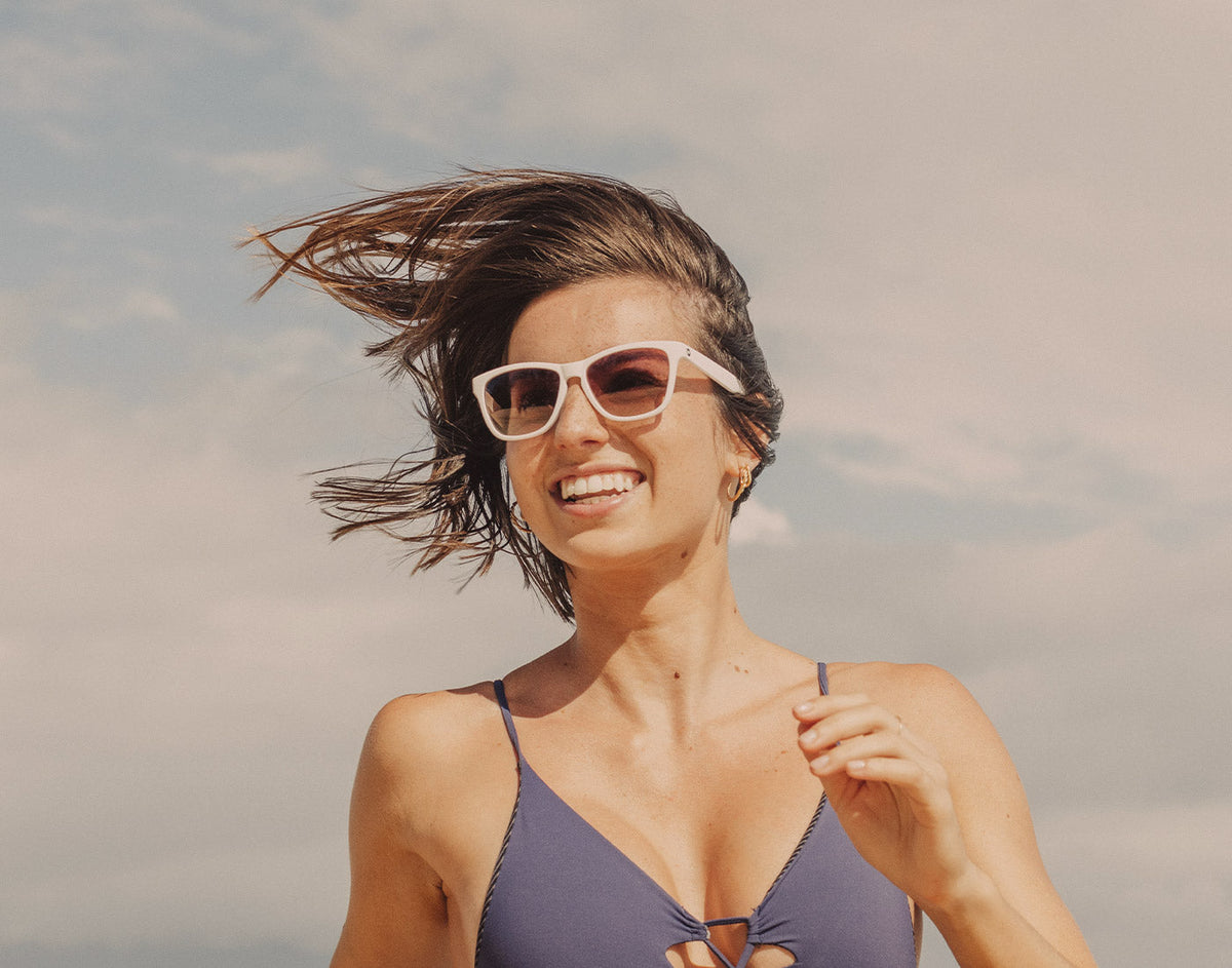 STORY girl running and smiling wearing sunski headland sunglasses