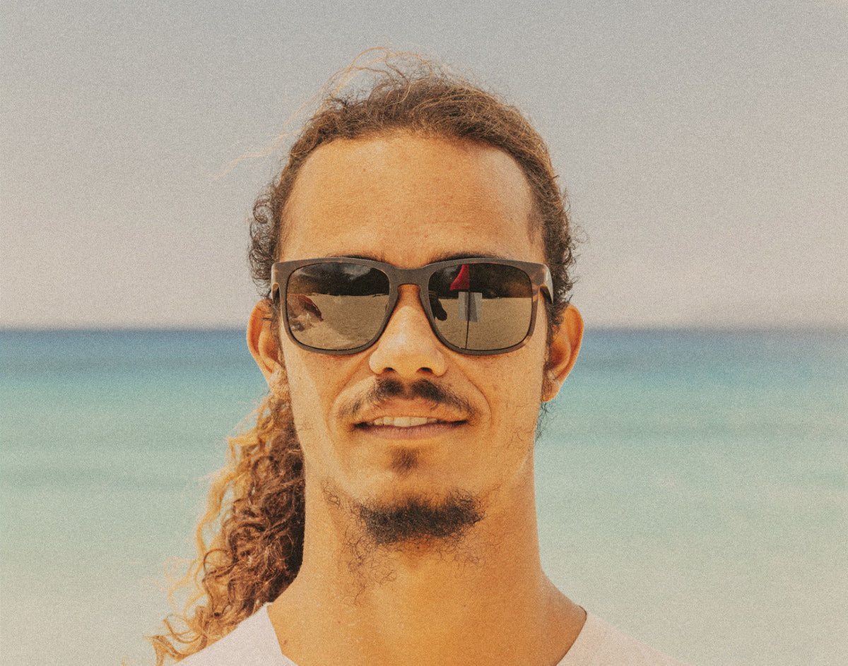 STORY man on beach wearing sunski kiva sunglasses