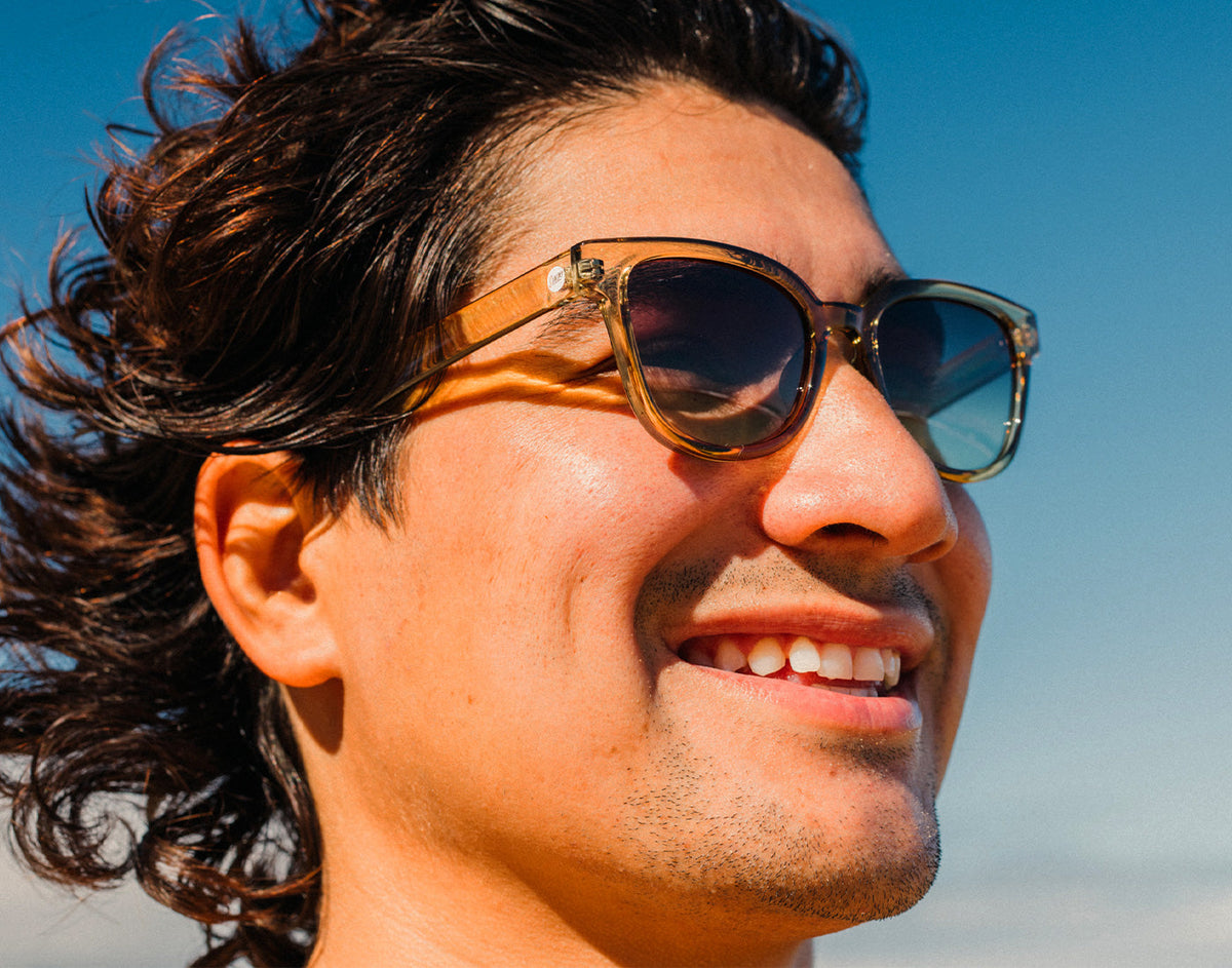 STORY profile of a man smiling wearing sunski miho sunglasses