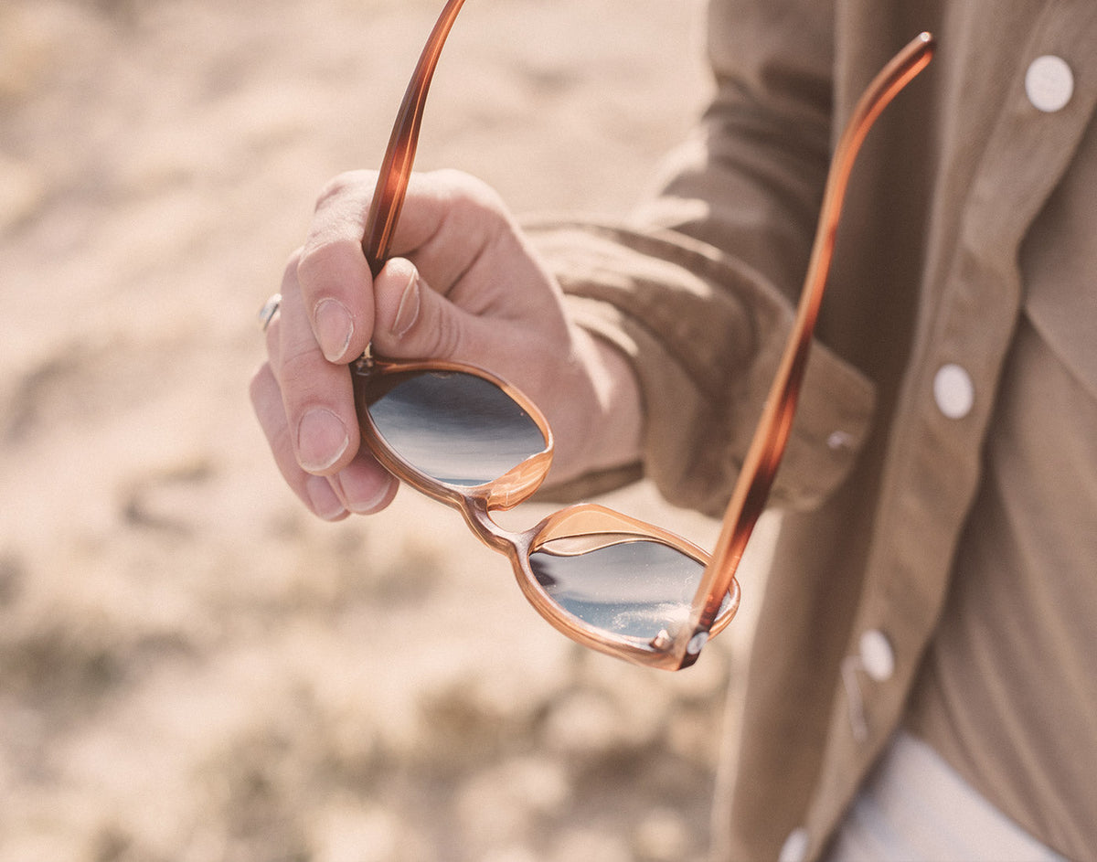STORY someone holding sunski yuba sunglasses facing down