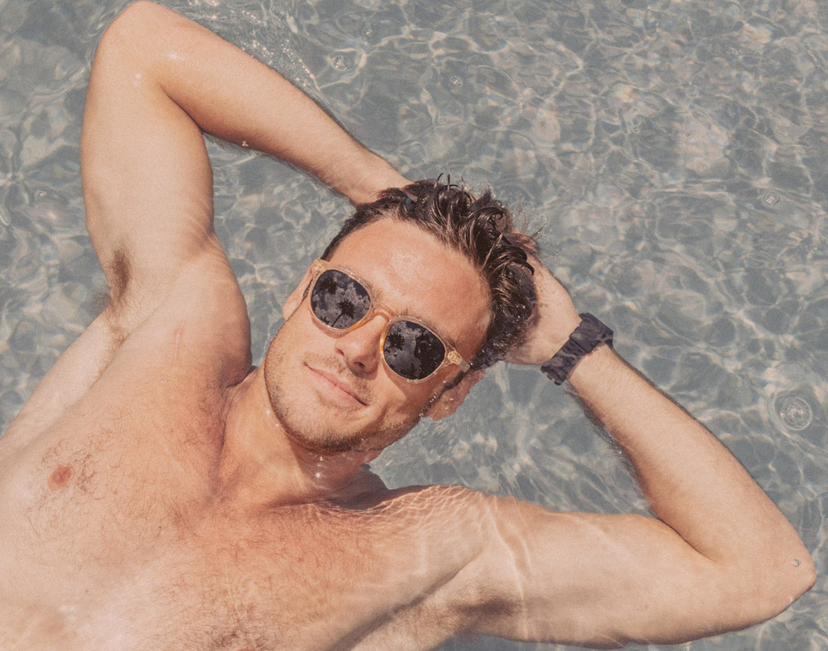 STORY guy floating in pool wearing sunski yuba sunglasses