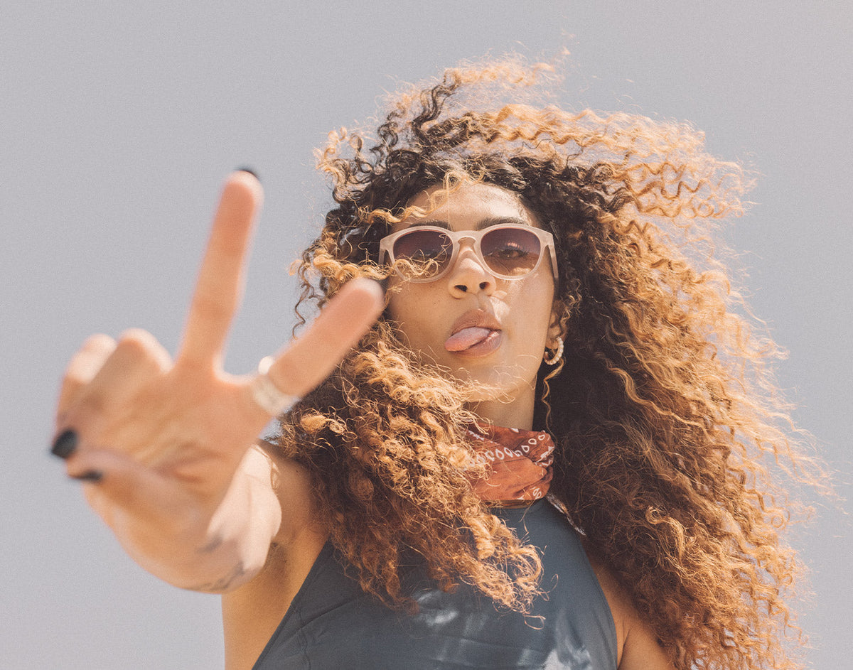 STORY girl sticking tongue out with peace sign wearing sunski yuba sunglasses