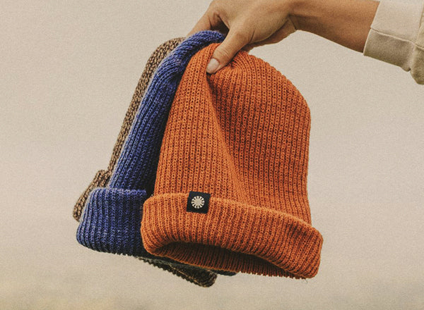 RICH sunski shoulder season beanie hand holding up all three colors