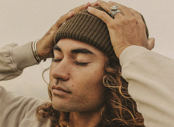 RICH guy with hands on head wearing sunski winter sun beanie