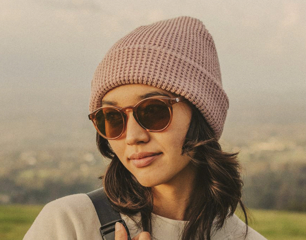 STORY woman wearing sunski sunglasses and sunski winter sun beanie