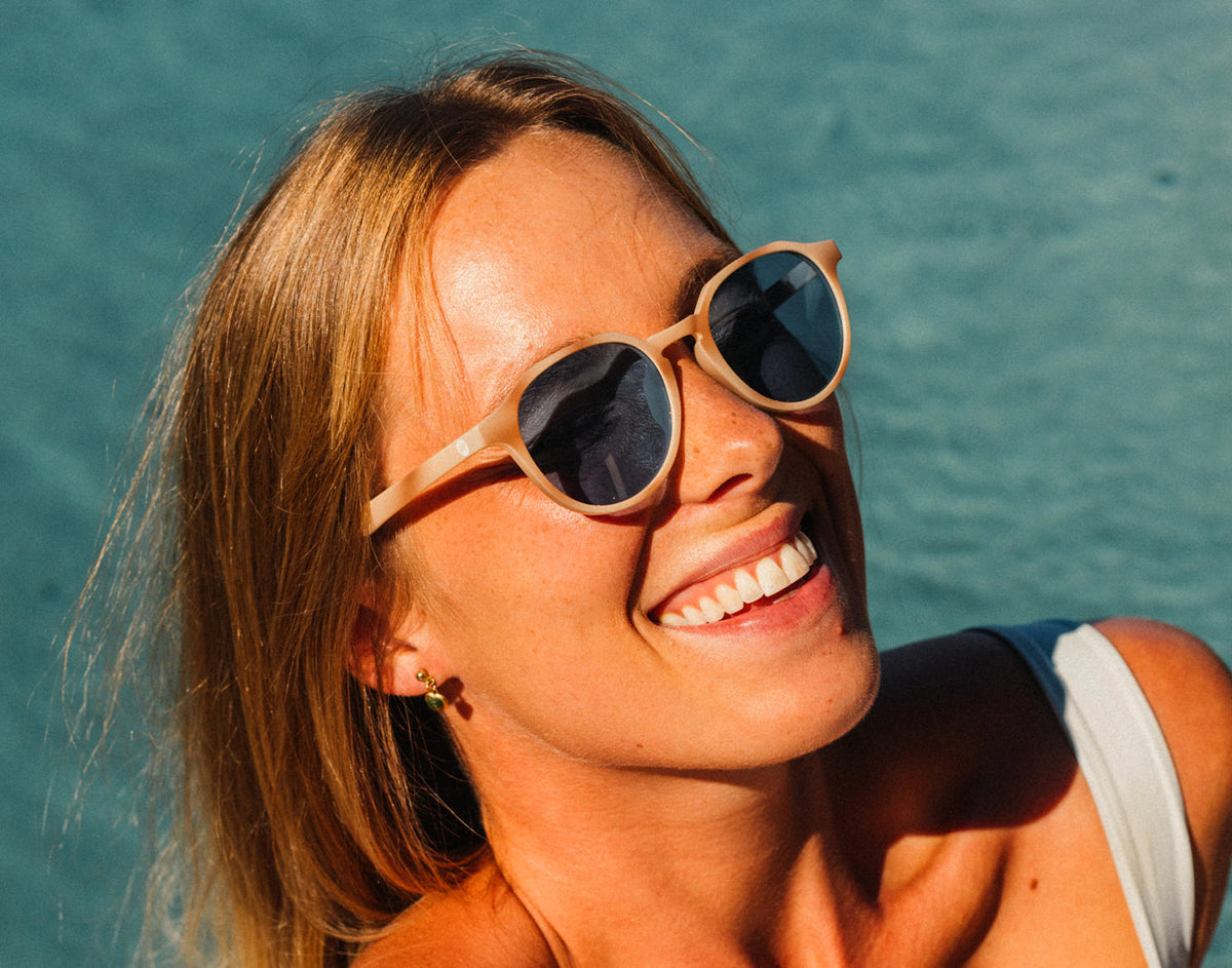STORY girl laughing by the pool wearing sunski vallarta sunglasses