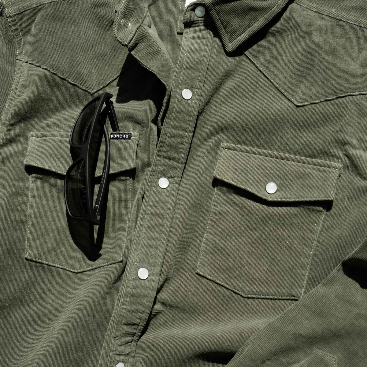 closeup of sunglasses slit on corduroy shirt